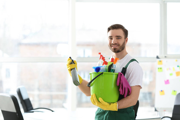 Homme concierge avec des fournitures de nettoyage dans le bureau
 - Photo, image