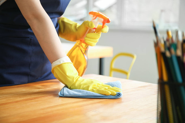 Female janitor cleaning table in office, closeup - Photo, Image