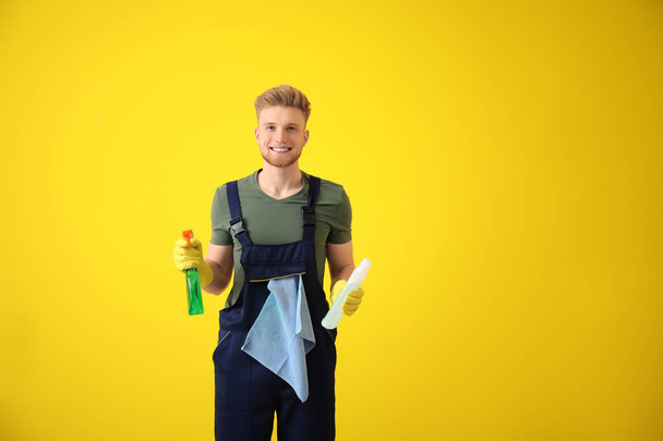 Ritratto di bidello maschio con prodotti per la pulizia su sfondo a colori
 - Foto, immagini