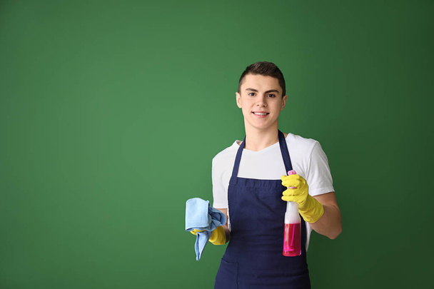 Πορτρέτο του άντρα επιστάτη με τα αναλώσιμα καθαρισμού στο χρώμα φόντο - Φωτογραφία, εικόνα