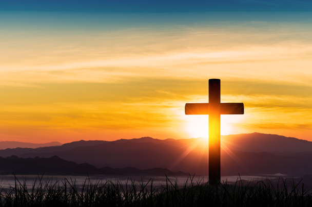 силует хреста на фоні гірського заходу сонця
. - Фото, зображення