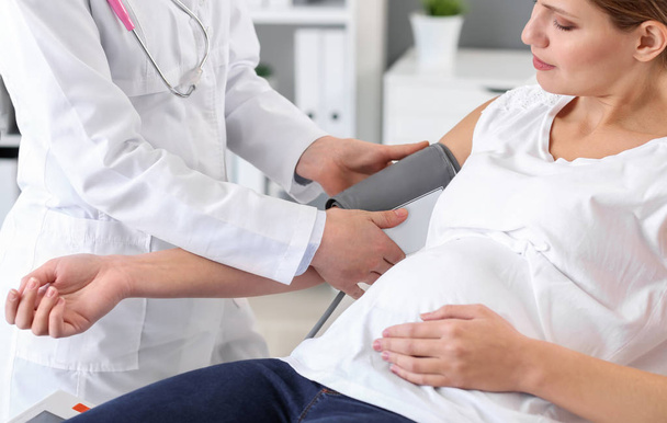 Jonge zwangere vrouw bezoekt haar gynaecoloog in kliniek - Foto, afbeelding