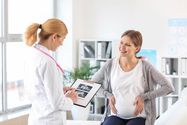 Jeune femme enceinte rendant visite à son gynécologue en clinique
 - Photo, image