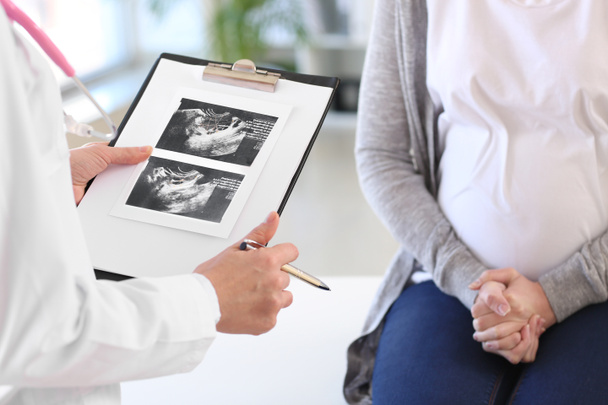 Mujer embarazada joven visitando a su ginecólogo en la clínica
 - Foto, Imagen