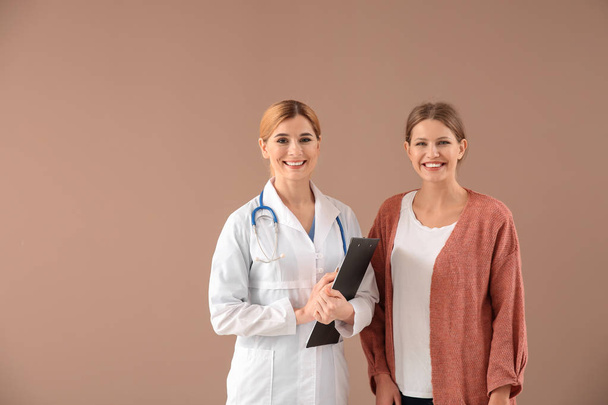 Gynaecoloog met patiënt op kleur achtergrond - Foto, afbeelding