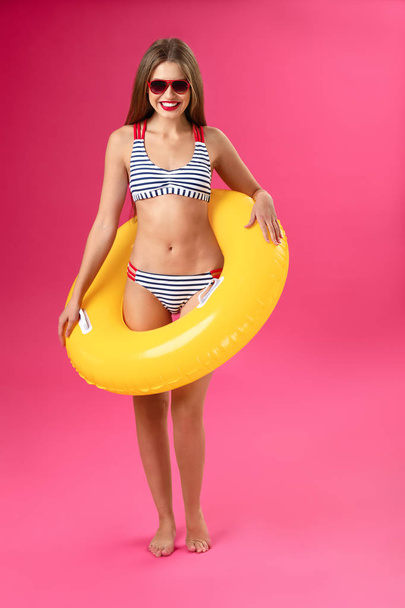 Beautiful young woman with inflatable ring on color background - Photo, Image