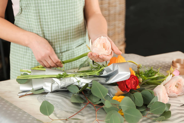 Florist making beautiful bouquet at table - Fotografie, Obrázek