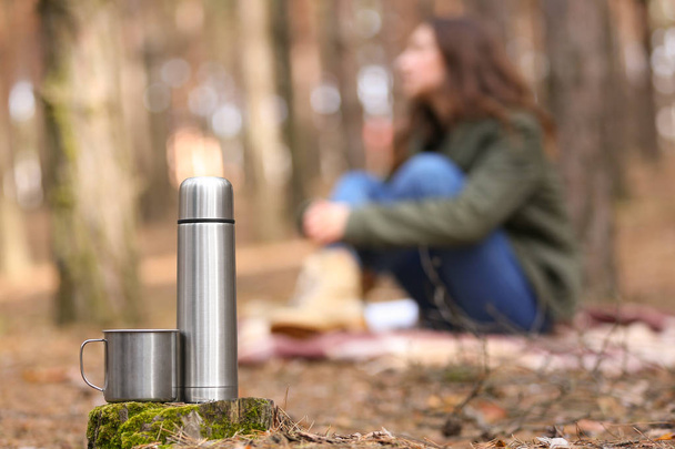 Thermos and mug of tourist in forest - Photo, Image