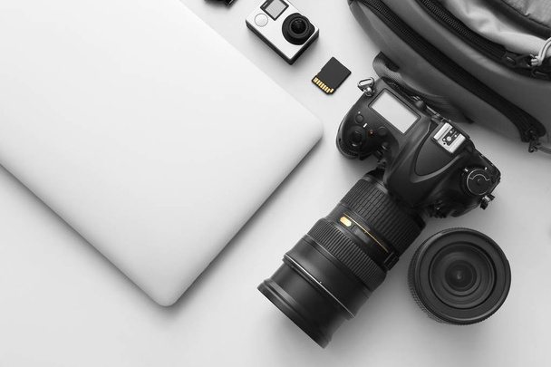 Equipamiento moderno de fotógrafo profesional con portátil sobre fondo claro
 - Foto, Imagen