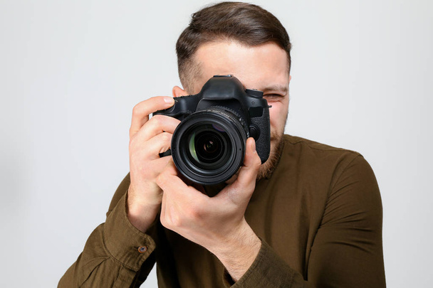 Αρσενικός φωτογράφος σε ανοιχτόχρωμο φόντο - Φωτογραφία, εικόνα