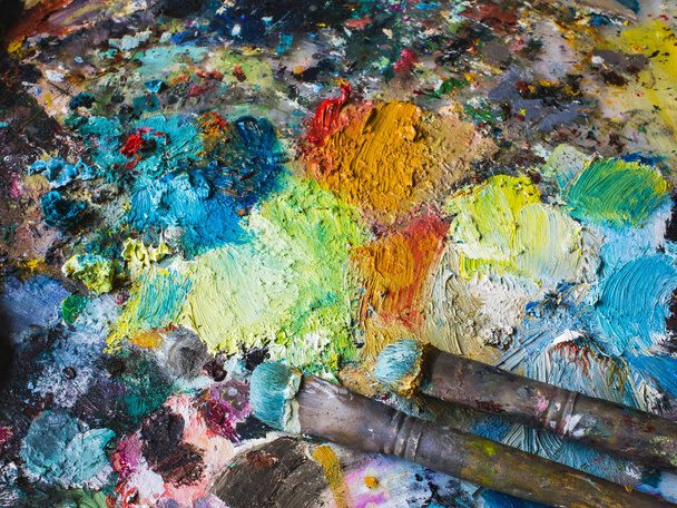 Старі зношені пензлі на текстурованому тлі барвистого р
 - Фото, зображення