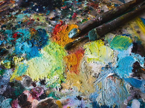 Mezcla de pinturas al óleo en la paleta con varios colores, vista superior
. - Foto, Imagen