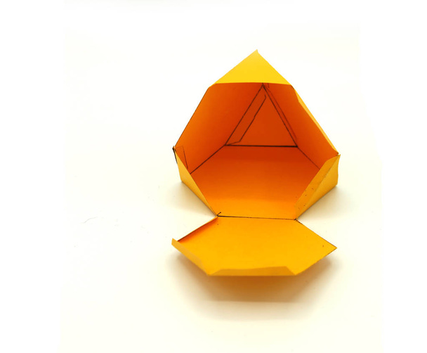 Forma geométrica cortada de papel amarillo y fotografiada sobre fondo blanco.Red geométrica de tetraedro truncado. Desplegado tres figuras dimensionales
. - Foto, Imagen