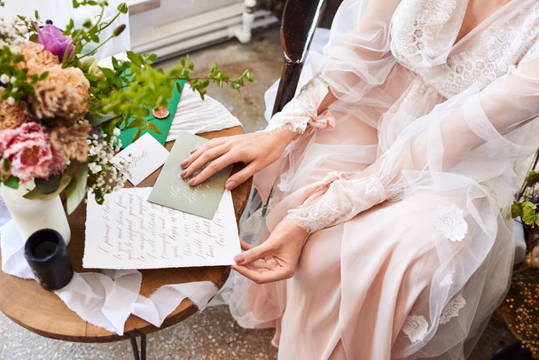 結婚式の日花嫁は窓の近くに座って、新郎に手紙を読みます。結婚の誓いだ準備。花嫁の朝 - 写真・画像
