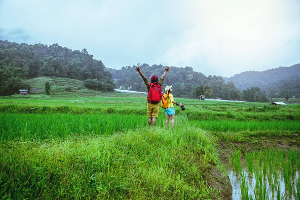 Amante Hombre asiático Las mujeres asiáticas viajan naturaleza Viajar relajarse Caminar una foto en el campo de arroz en temporada de lluvias en Chiang Mai, Tailandia
 - Foto, Imagen