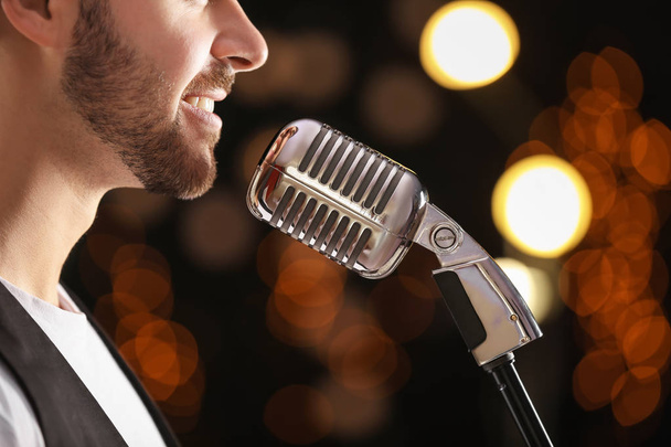 Handsome male singer with microphone on stage - Foto, Imagen