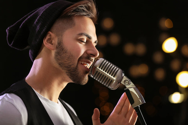 Jóképű férfi énekes mikrofonnal a színpadon - Fotó, kép