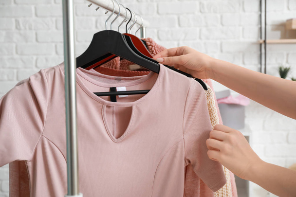 Woman choosing clothes in dressing room - Φωτογραφία, εικόνα