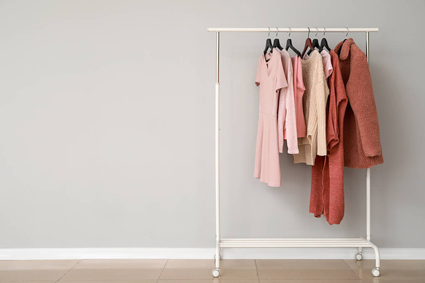 Rack with stylish clothes near grey wall - Фото, изображение