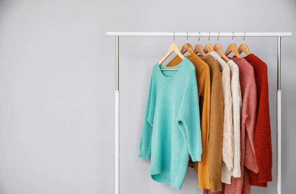 Rack with stylish clothes on grey background - 写真・画像
