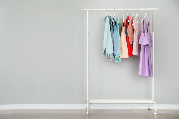 Rack with stylish children's clothes near light wall - Photo, Image