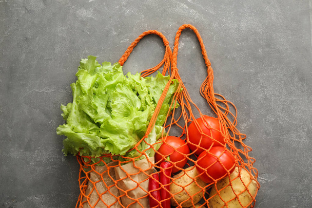 Légumes frais avec sac à provisions en mesh sur fond grunge. Concept zéro déchet
 - Photo, image
