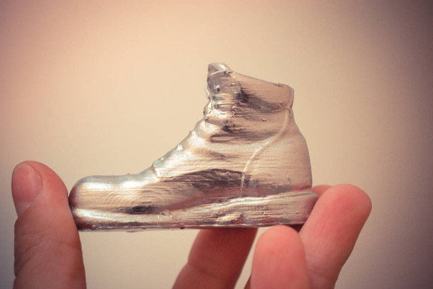 Objeto na forma de uma bota impressa em uma impressora 3d e coberta com esmalte - Foto, Imagem