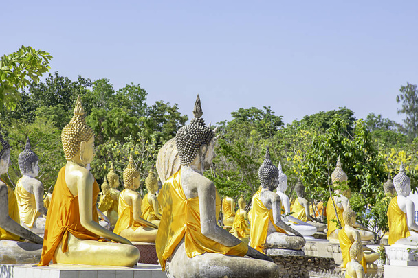 Detrás de la estatua de Buda cubierta de tela amarilla Cielo de fondo en Wat Phai Rong Wua, Suphan Buri en Tailandia
. - Foto, imagen