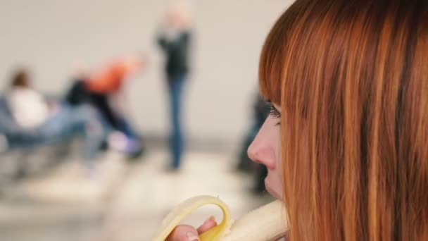 Banaani. Tyttö syö banaanin julkisella paikalla.
 - Materiaali, video
