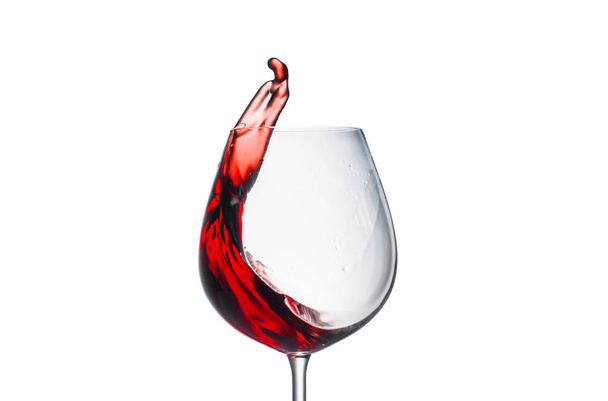 spritzender Rotwein in einem Glas auf weißem Hintergrund - Foto, Bild