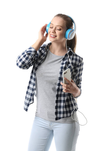 Belle jeune femme écoutant de la musique sur fond blanc - Photo, image