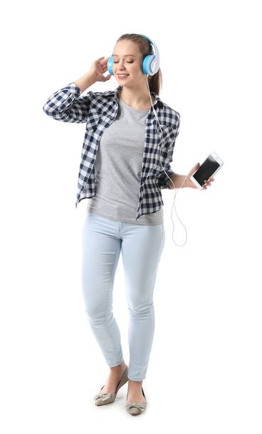 Schöne junge Frau hört Musik auf weißem Hintergrund - Foto, Bild