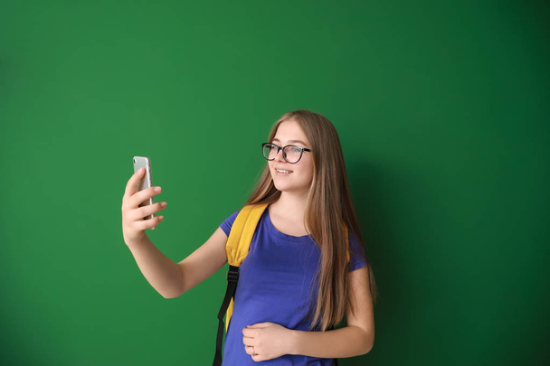 Cute nastoletnie dziewczyny biorąc selfie na kolorowym tle - Zdjęcie, obraz