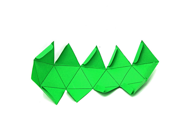 Forma geometrica ritagliata su carta e fotografata su sfondo bianco. Geometria rete di solidi platonici Icosaedro. Forma bidimensionale che può essere piegata per formare una forma tridimensionale o un solido
. - Foto, immagini