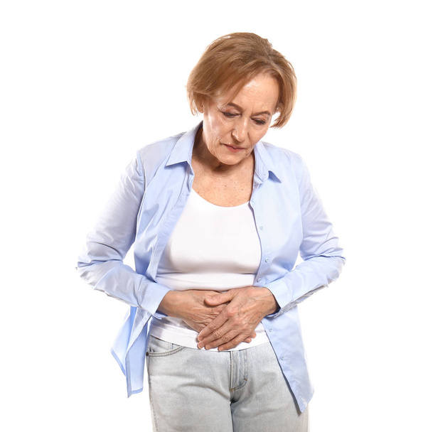 Beautiful mature woman suffering from stomach ache against white background - Fotoğraf, Görsel