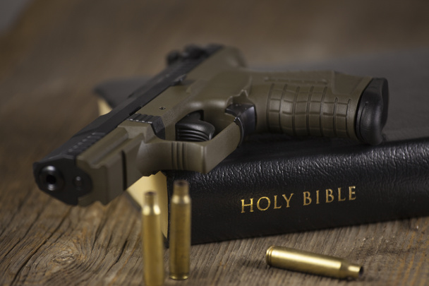 Pistol and Bible with empty bullets. - Photo, Image