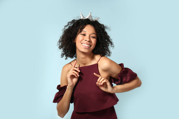 Счастливая афроамериканка в короне на цветном фоне
 - Фото, изображение