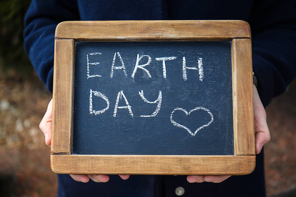Nő kezében tábla szöveges Earth Day szabadban, közelkép - Fotó, kép