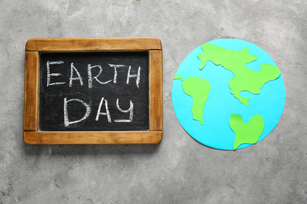 Kreidetafel mit Text Tag der Erde und Form des Planeten auf Grunge-Hintergrund - Foto, Bild