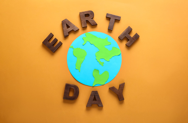 Text EARTH DAY composed from letters and shape of planet on color background - Photo, Image