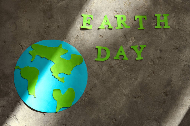 Text Earth Day bestehend aus Buchstaben und Gestalt des Planeten auf Grunge-Hintergrund - Foto, Bild