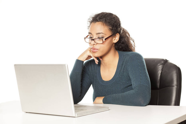 молода афро-американка з красивим обличчям, використовуючи ноутбук, робочий проект за столом на білому тлі
 - Фото, зображення