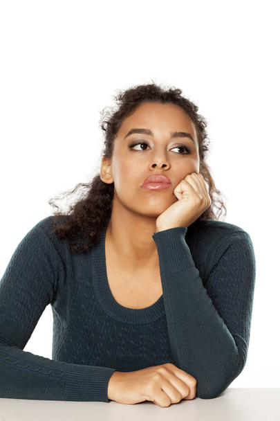 fiatal, szomorú, sötét bőrű nő portréja fehér alapon - Fotó, kép