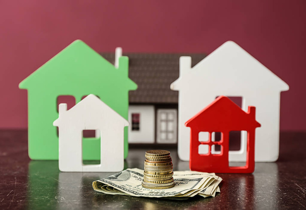Figury domów i pieniędzy na stole. Koncepcja zakupu nieruchomości - Zdjęcie, obraz
