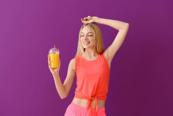Szép fiatal nő, friss gyümölcslé színes háttér - Fotó, kép