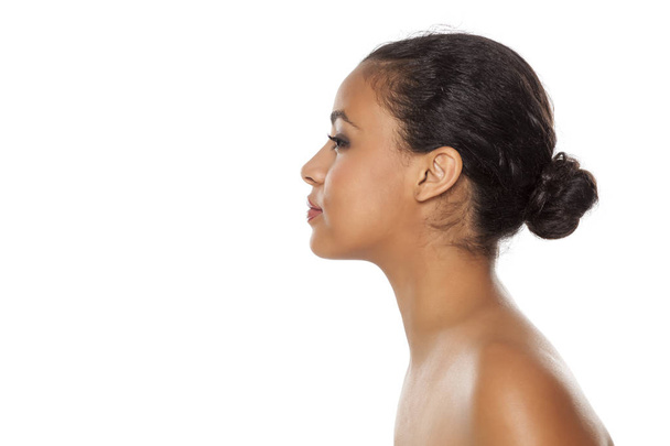Profil mladé ženy s tmavou kůží s houšovou na bílém pozadí - Fotografie, Obrázek