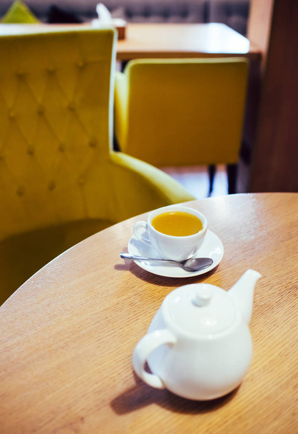 Csésze tea és fehér kerámia teáskanna - Fotó, kép