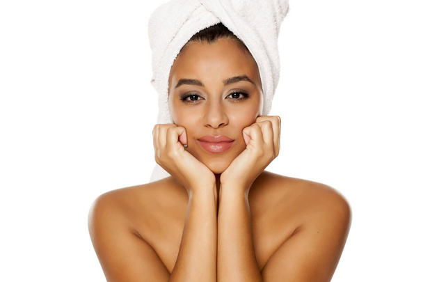 Portret młodej pięknej kobiecej ciemnej skóry z ręcznikiem na głowie, stwarzając na białym tle - Zdjęcie, obraz