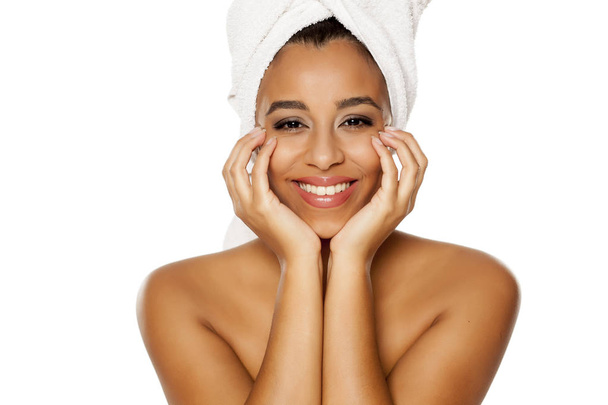portrait of young beautiful dark-skinned woman with towel on her head, posing on a white background - Photo, image