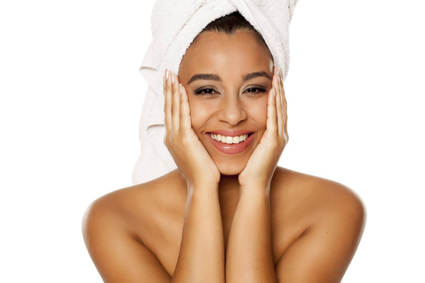 πορτρέτο της νεαρής όμορφο σκούρο-δέρμα γυναίκα με πετσέτα στο κεφάλι της, ποζάρισμα σε λευκό φόντο - Φωτογραφία, εικόνα
